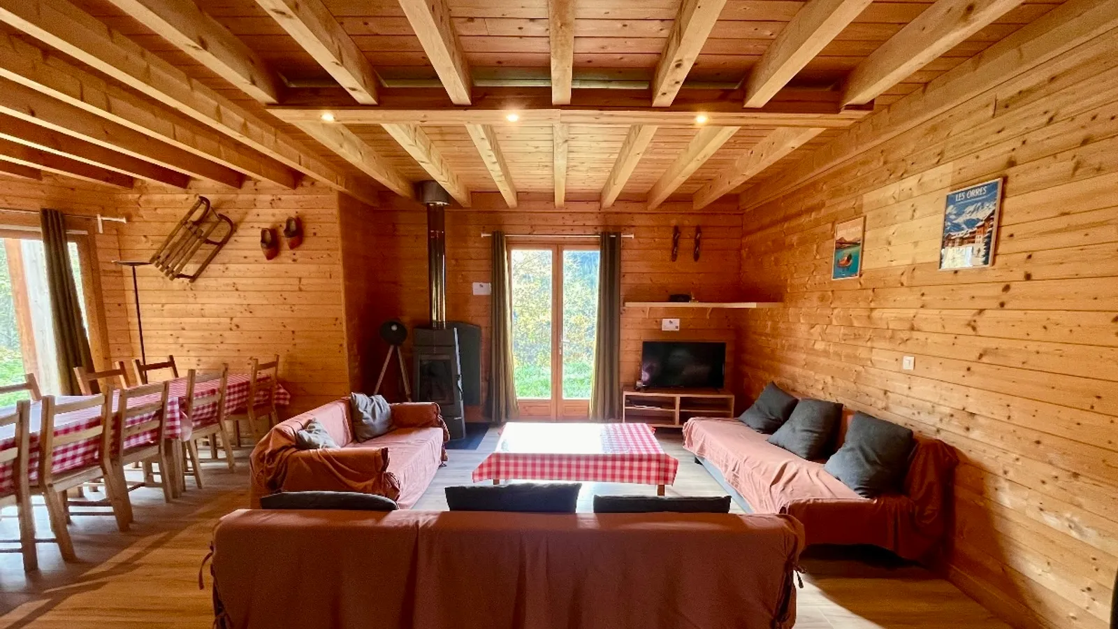 Salon du chalet avec poêle à bois et canapés, aux Orres
